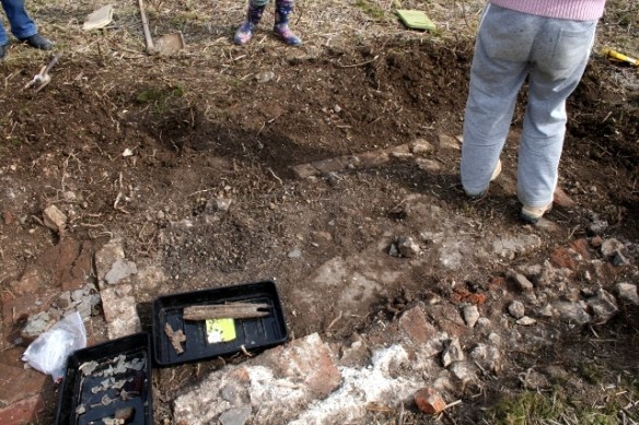 Trench 1A showing un-mortared bricks edging its E side and exterior wall to its W