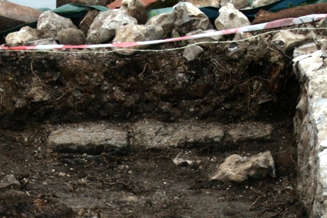 Row of stones about 30cm N of front of house