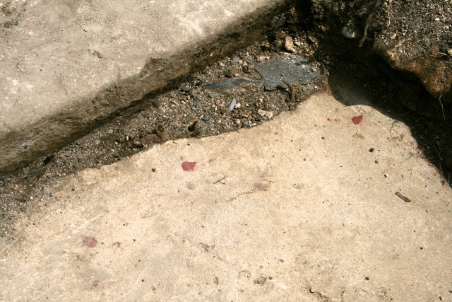 Red paint drops on stones exterior to toilet