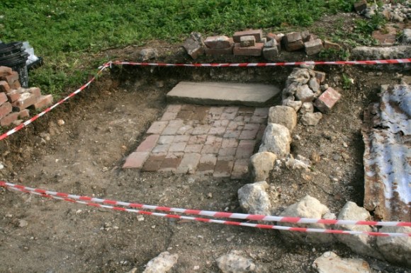 Looking SE from corner of toilet at stone edged, earth and brick paths (& yard?)