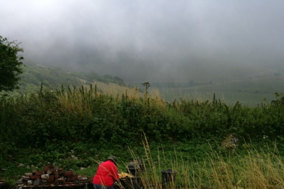 View ESE from site of big barn over site of cottage front door, demolition rubble mound, and Castle Hill beyond