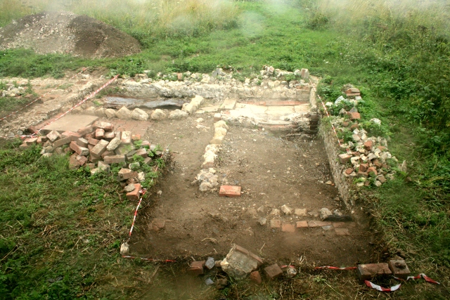 Looking W across excavated area N of house from bulldozed rubble mound