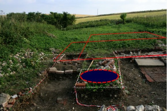 Photo of exvacavtion with wall lines and possible location of a well drawn in