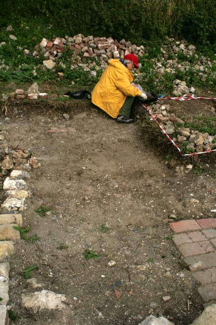 Looking E from patth between toilet and front door to house; excavating square midway between front garden gate and front of house