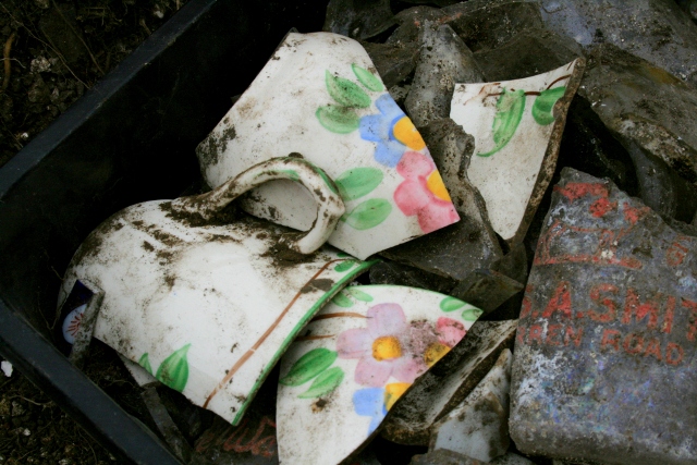 Porcelain cup shards with colourful flower design and intact handle