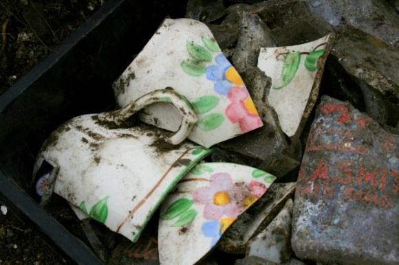 Porcelain cup shards with colourful flower design and intact handle