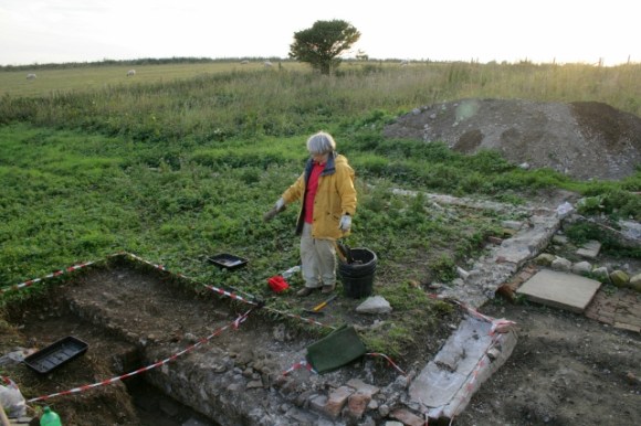 Looking SW from near N end of rubble mound across NE corner of kitchen towards SW corner of farmyard (just behind tree)