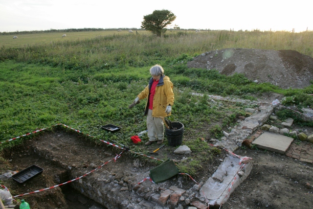 Looking SW from near N end of rubble mound across NE corner of kitchen towards SW corner of farmyard (just behind tree)
