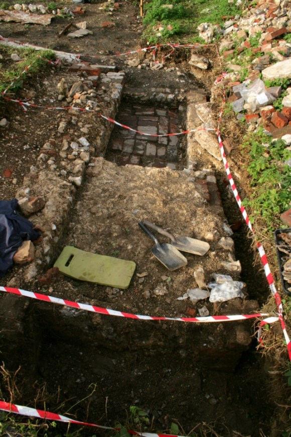 Looking N from site of fireplace on E wall of cottage at concrete platform and 'woodstore' beyond