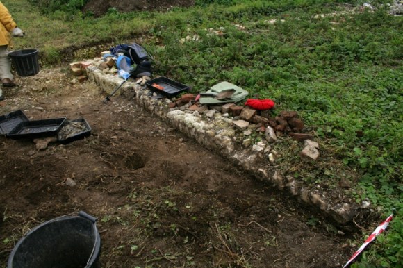 Looking NW at a small hole dug in the trench where an end of the 'bucket handle' was found