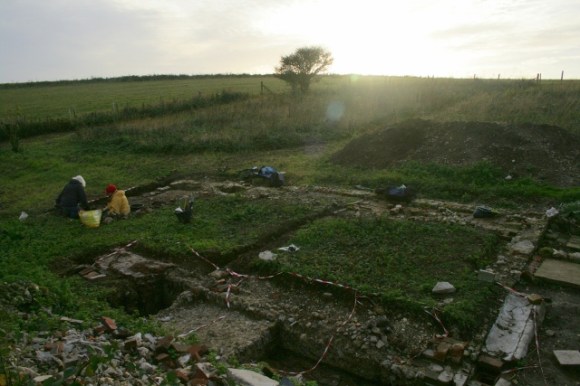 Looking SW from demolition rubble mound at excavation S of cottage