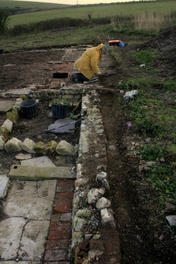 Looking S at boundary wall between cottage/garden and farmyard