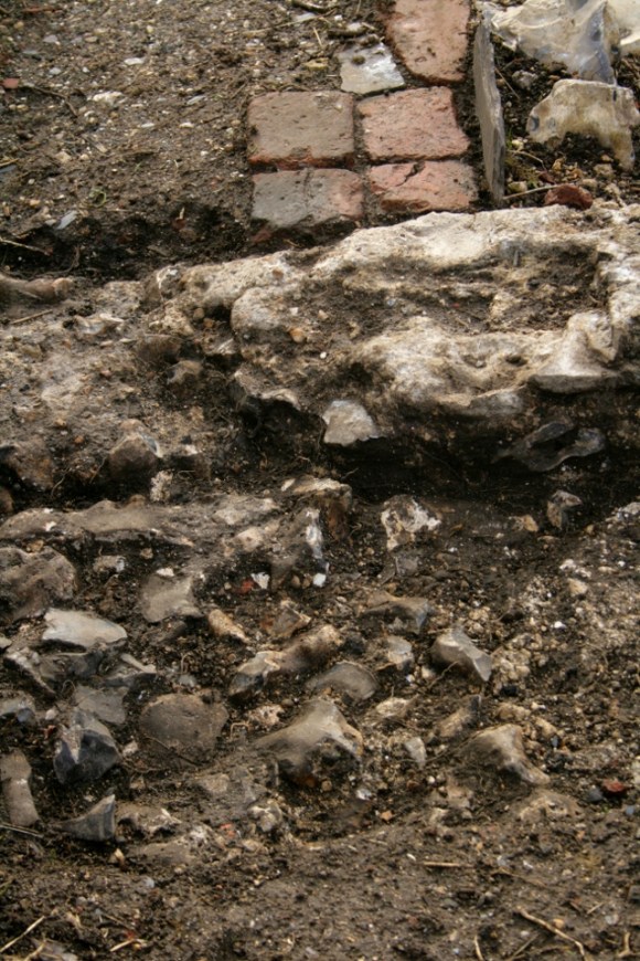 Looking S at cobbled surface N of garden gateway with brick paving on W path edge to S