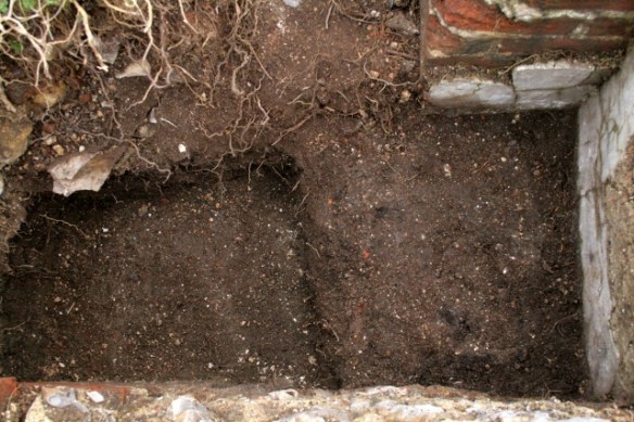 Looking S at gap between bases of 'laundry copper' and chimney