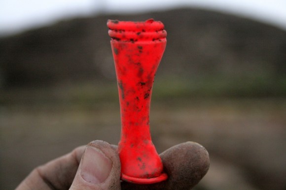 Half a split red plastic (PVC?) waisted cylinder