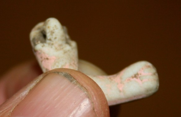 A small articulated arm of a bisque doll
