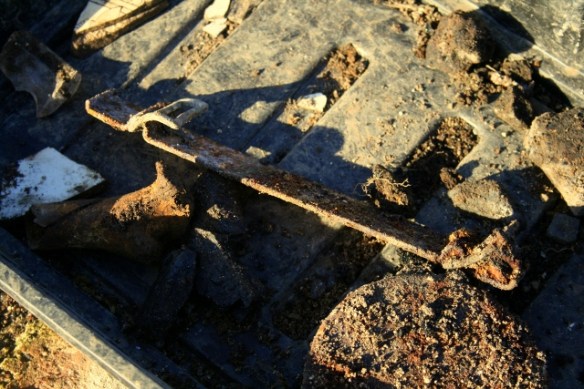 Finds tray containing a metal ammunition box(?) handle attachment