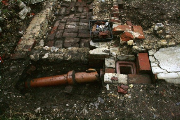 Looking S at NE corner of cottage and excavated gully drain in front of shed
