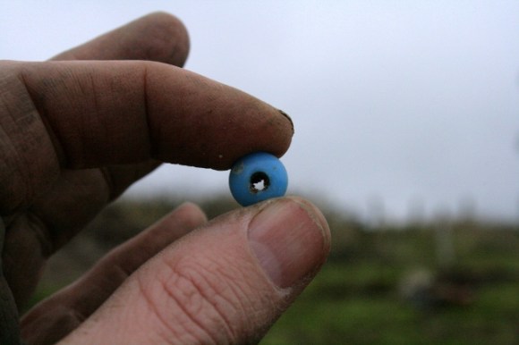 Light blue glass bead from footings of outside toilet