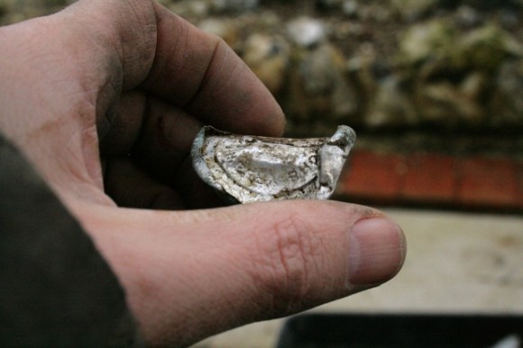 Aluminium foil milk bottle top from foundations of outside toilet