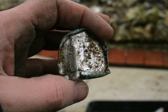 Aluminium foil milk bottle top from foundations of outside toilet