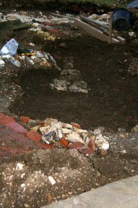 Looking NE at excavation of cobbled flint surface from front front door of cottage at front garden gateway; 9th February 2014