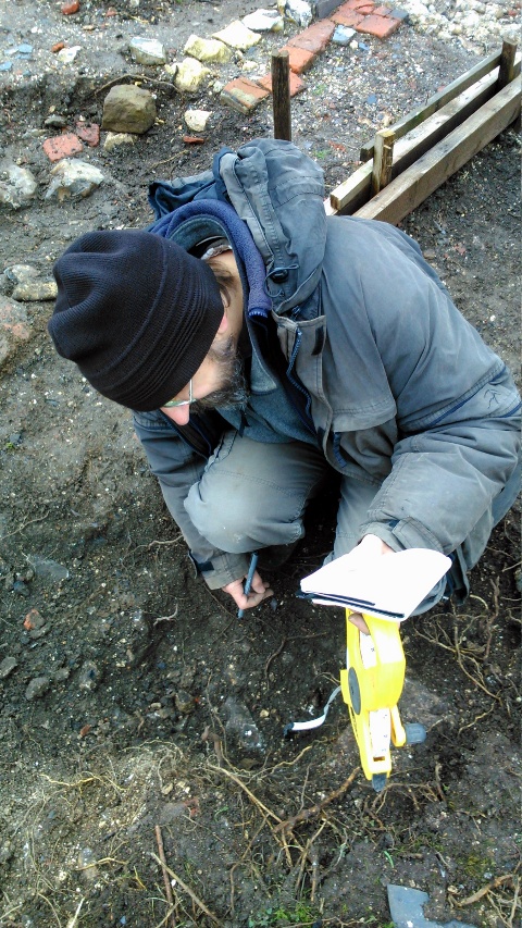Looking NW at me recording excavation of area between shed and front garden gate